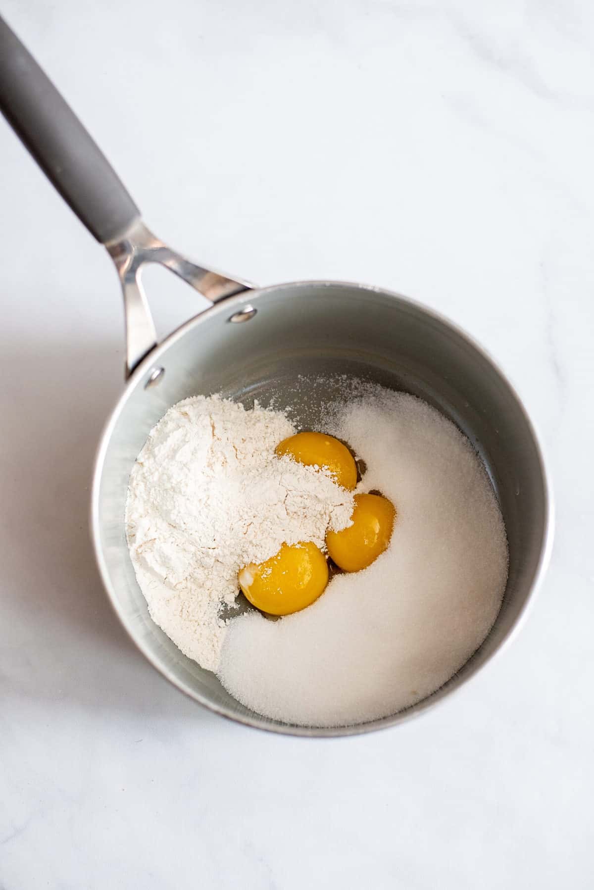 Add dry ingredients to yolks in saucepan.