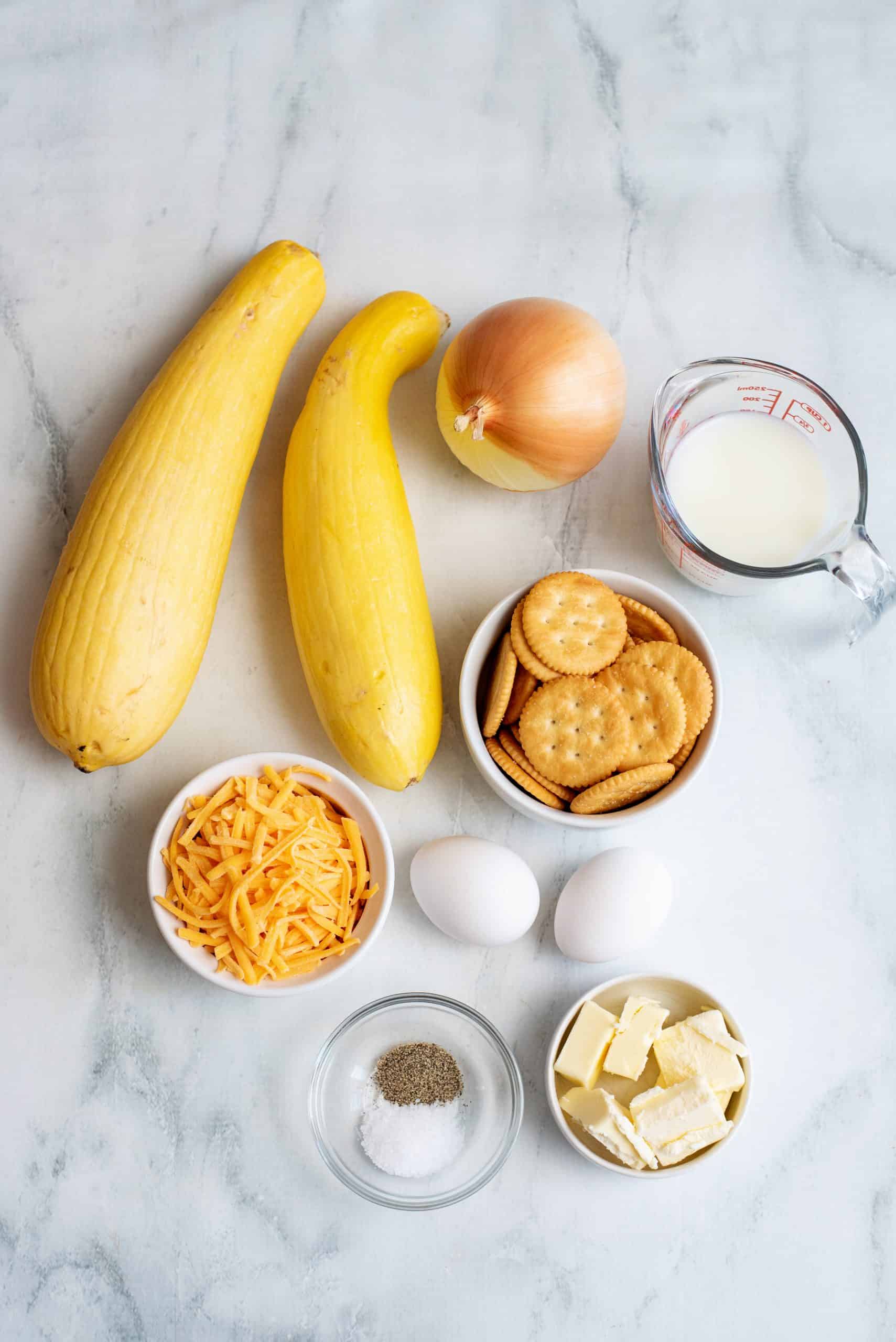 Ingredients for squash casserole, featuring squash, onion, butter, Ritz crackers, cheddar cheese, salt, pepper, milk, and eggs.