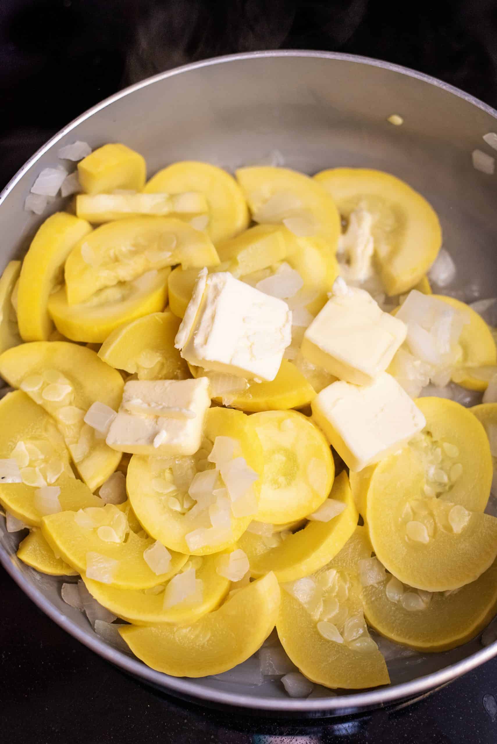 Butter sliced over squash in skillet.