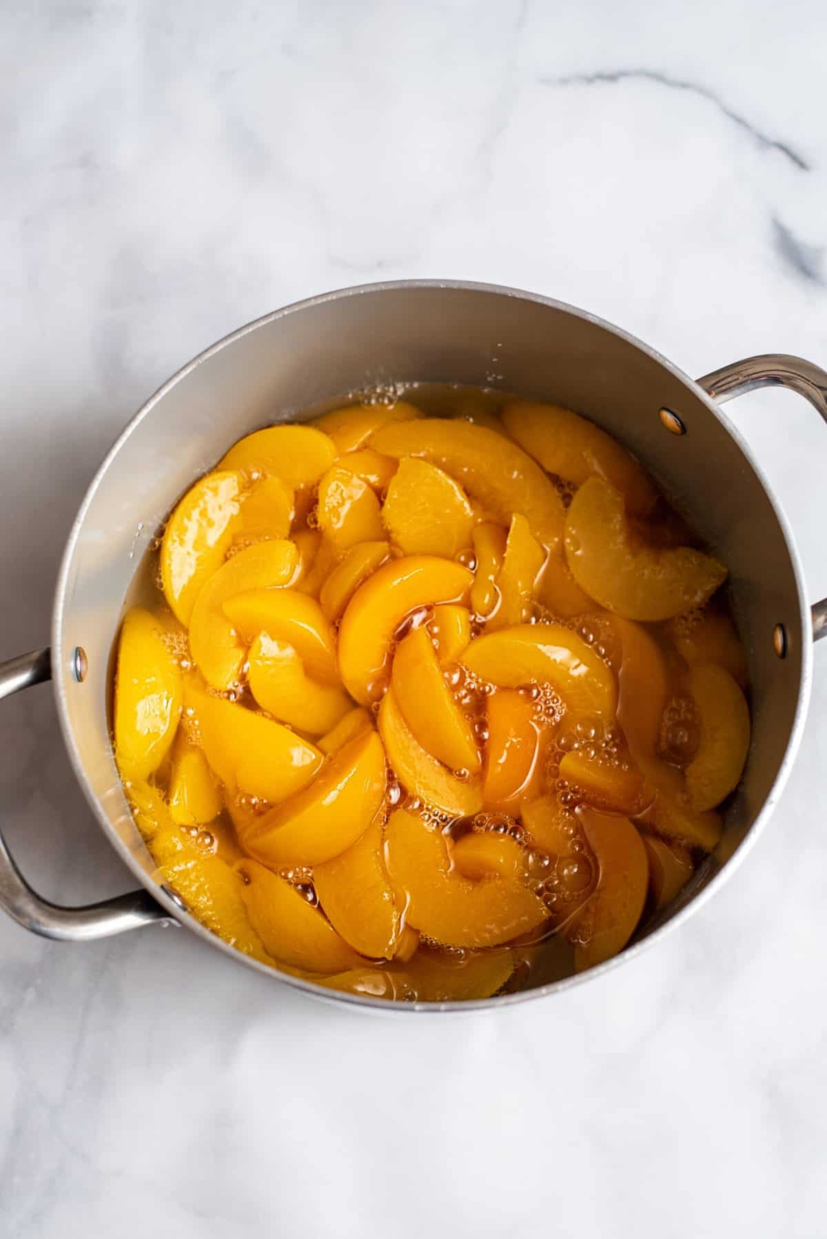 pour both cans of peaches into medium pot