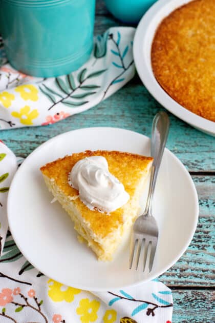 A slice of coconut pie topped with whipped cream.