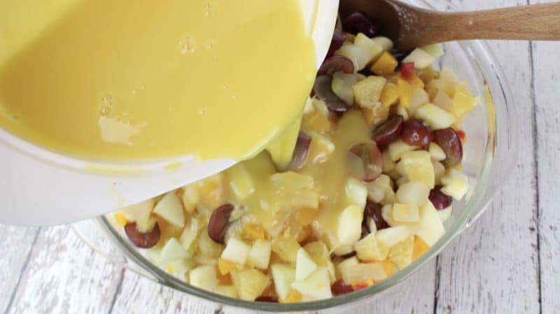 Pouring sauce over fruit salad.