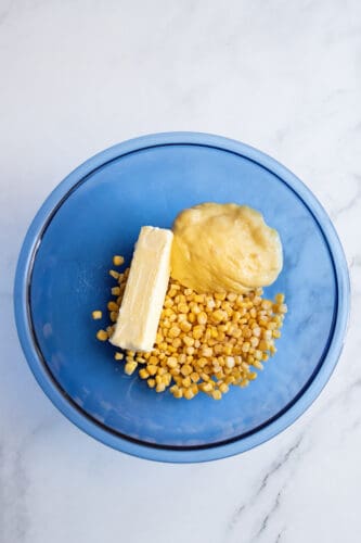 Stick of margarine, corn and soup in mixing bowl.