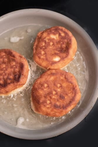 Golden brown biscuits cooking in oil.