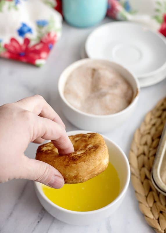 doughnut being dipped in melted butter