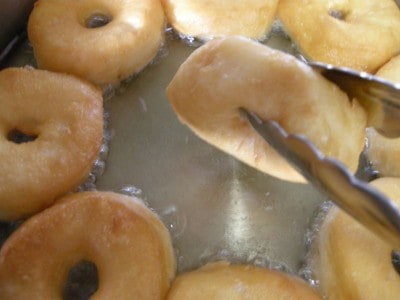 golden doughnuts ready to remove from oil.