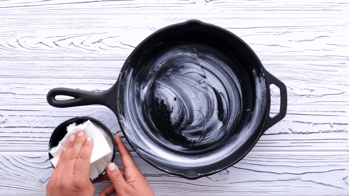 Seasoning a cast iron skillet with vegetable shortening.