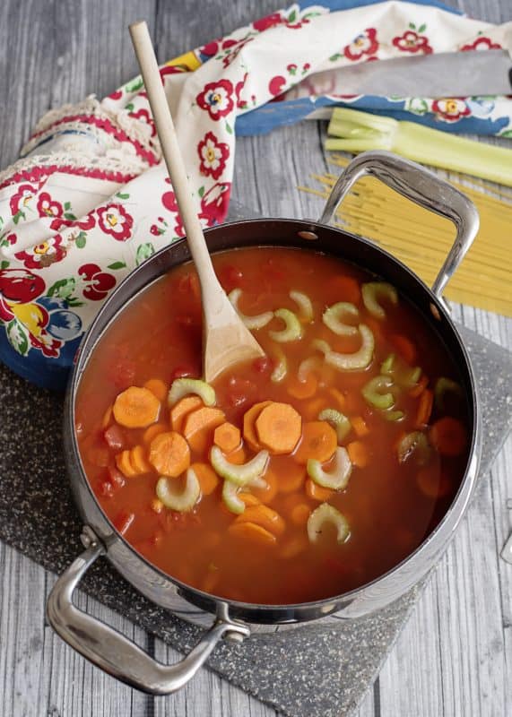 Adding veggies to pot.