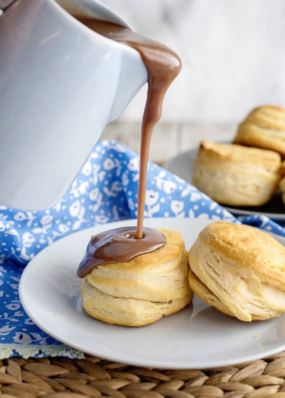 pouring chocolate gravy on biscuits.