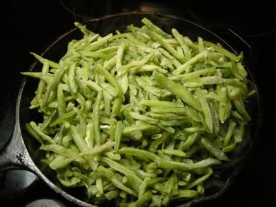 Place green beans in skillet with bacon grease.