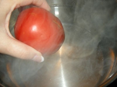 Add tomatoes to boiling pot of water.