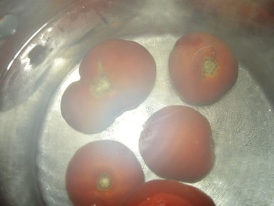 Tomatoes in pot of boiling water.