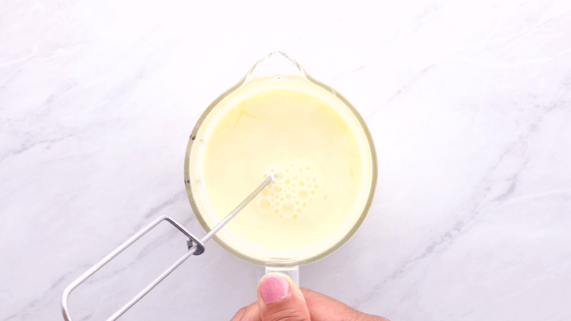 Whisking eggs and milk in measuring cup.