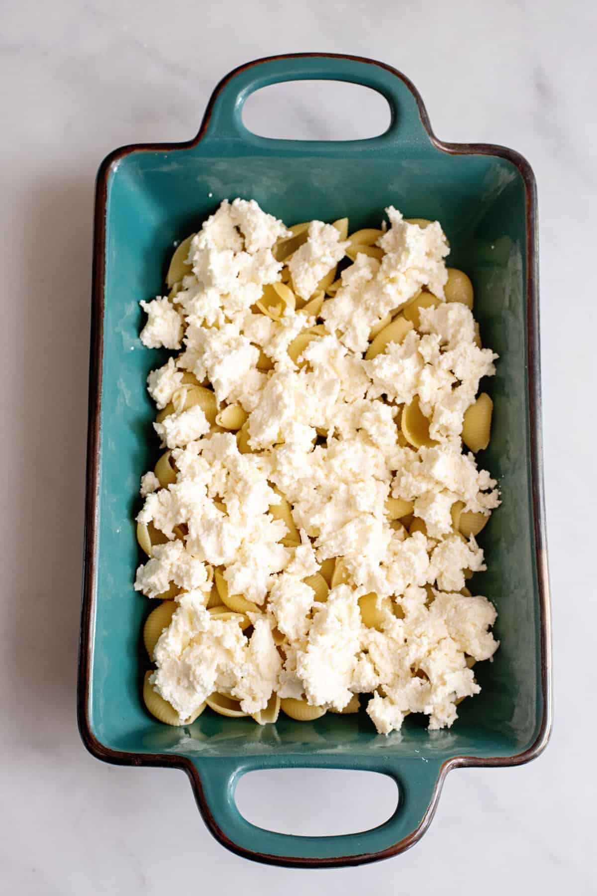 Spread half of the cheese over the pasta.