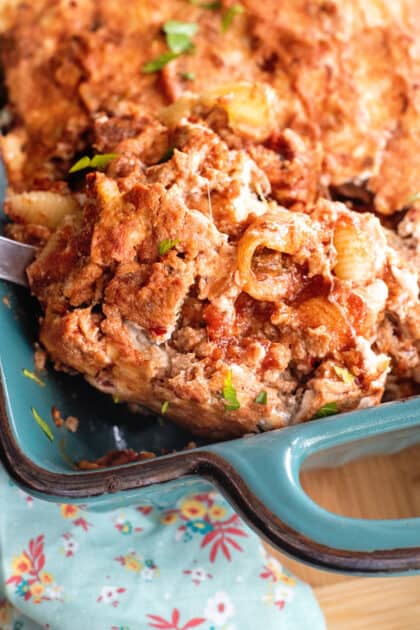 Close-up of ladle filled with meatloaf casserole.