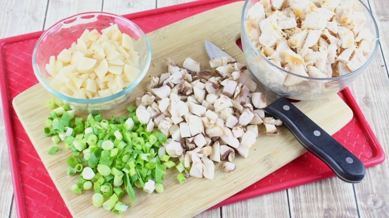 Chop up green onion, mushrooms, water chestnuts, and cooked chicken.