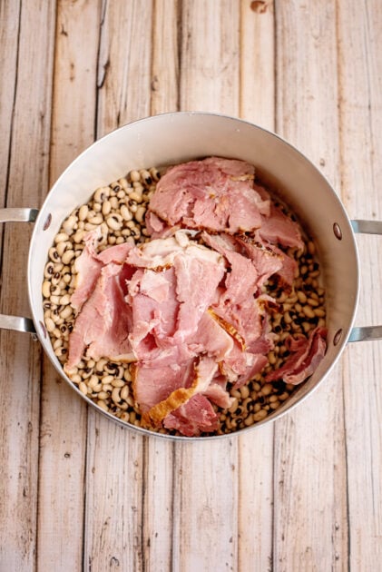 Add ham to black eyed peas in pot.