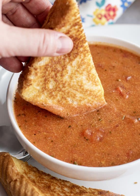 Dipping grilled cheese into tomato soup.