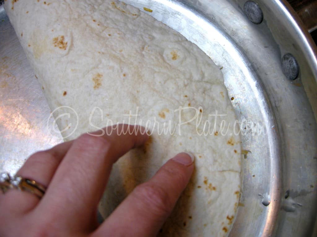 Folding the tortilla over the filling in the skillet
