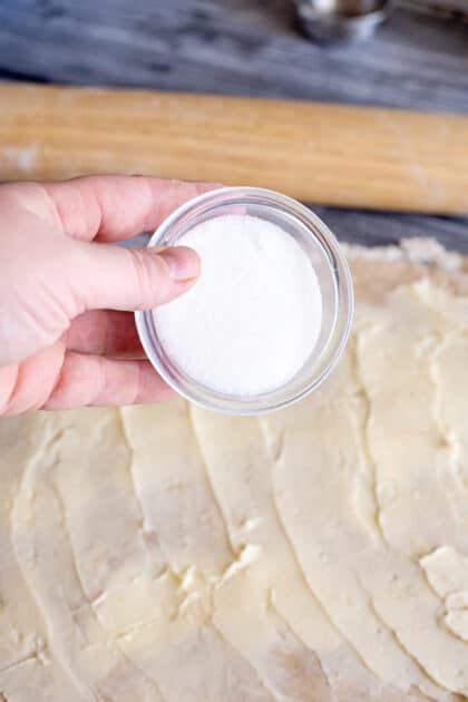 Add sugar to rolled-out dough.