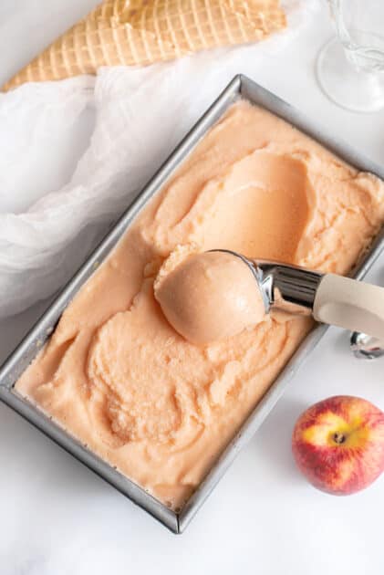 Large container of homemade peach ice cream.