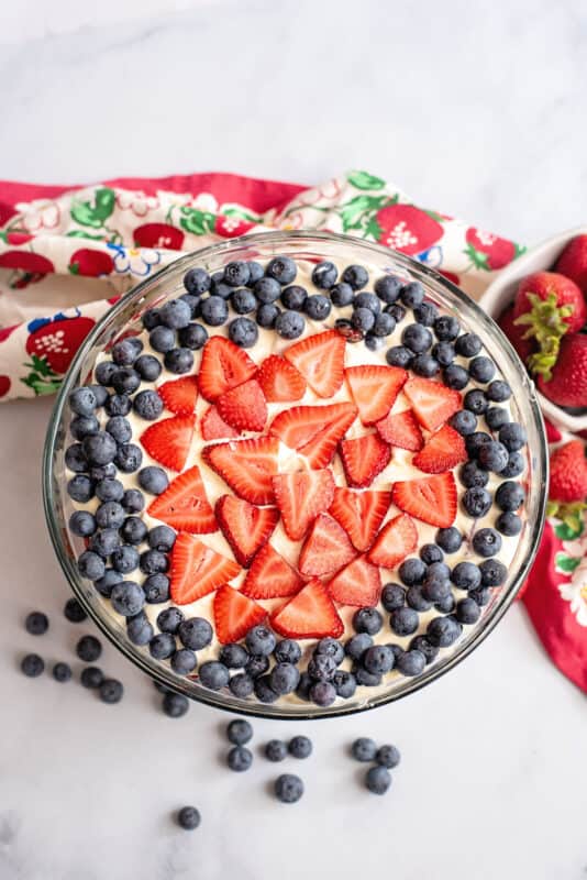 Patriotic punch bowl cake topped with more berries.