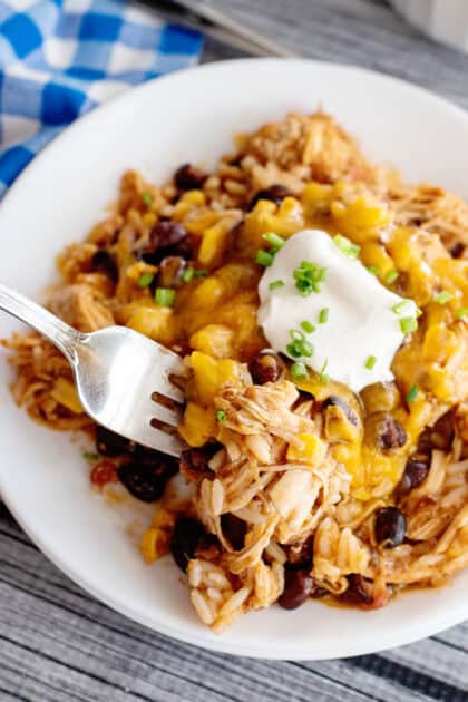 Fork digging into crockpot fiesta chicken and rice.