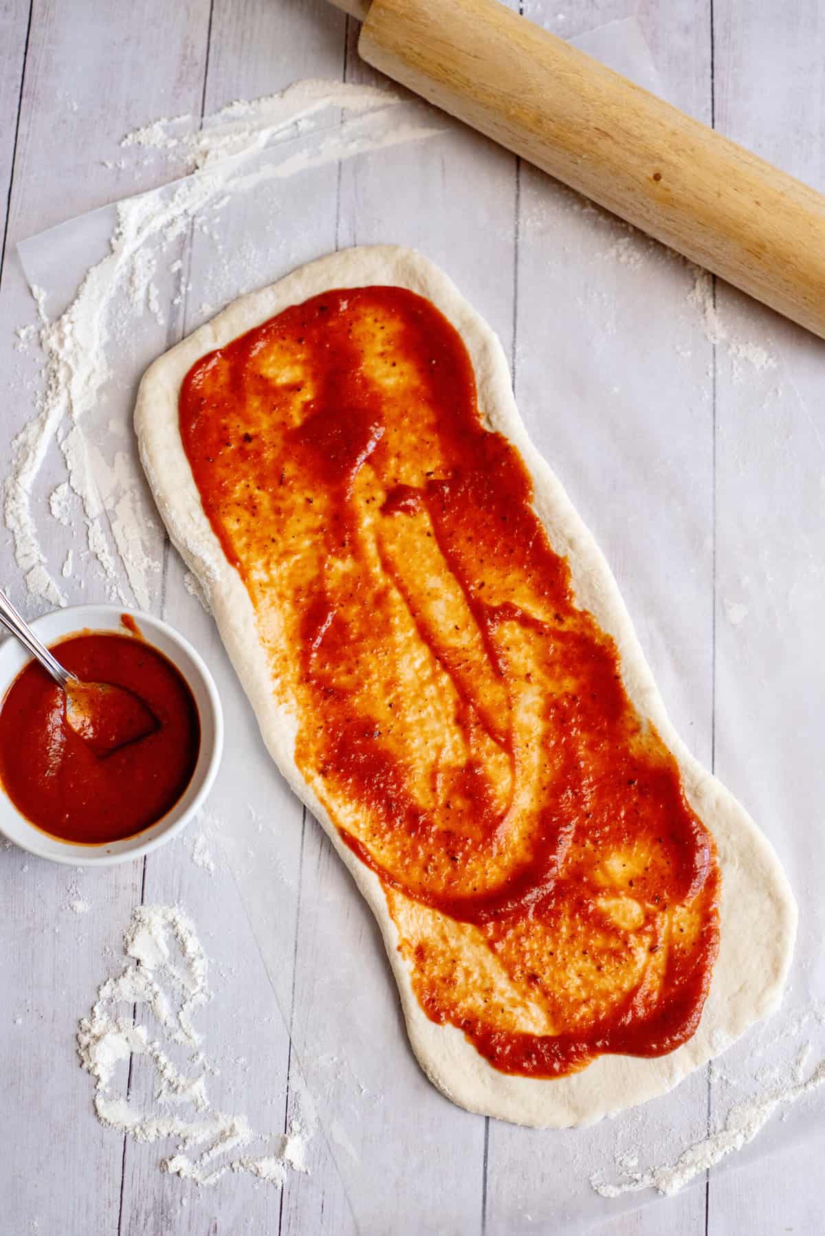 spread pizza sauce over the dough for stuffed pizza sticks