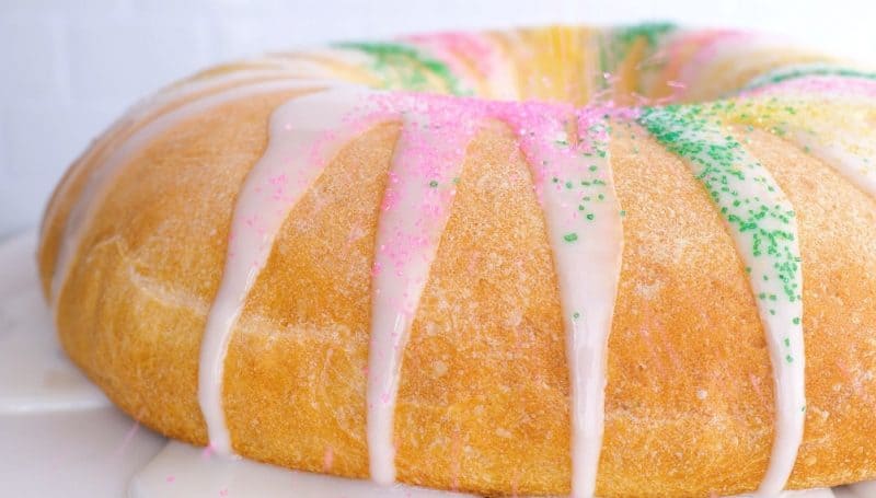 Icing drizzling down sides of king cake.