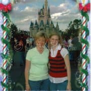 A mother and daughter posing in front of the Walt Disney World Castle.