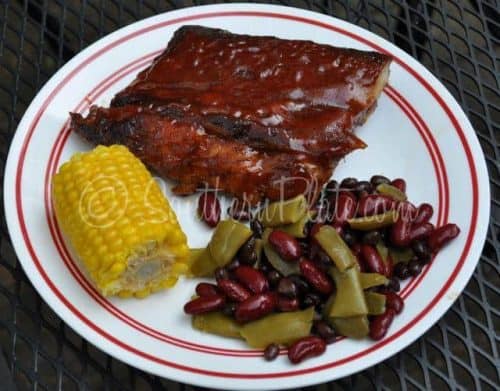 Oven-baked baby back ribs served with sides.