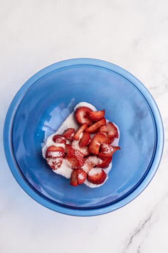 Place strawberries and sugar in bowl.