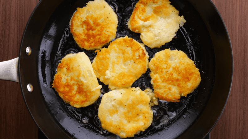 Browned potato cakes in skillet.