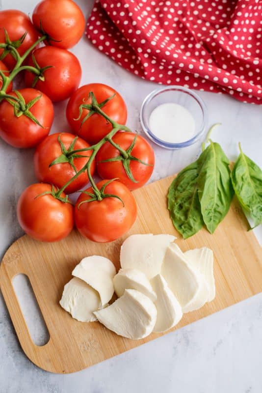 Ingredients for baked tomatoes with mozzarella and basil.