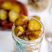 Jar of overflowing candied dill pickles.