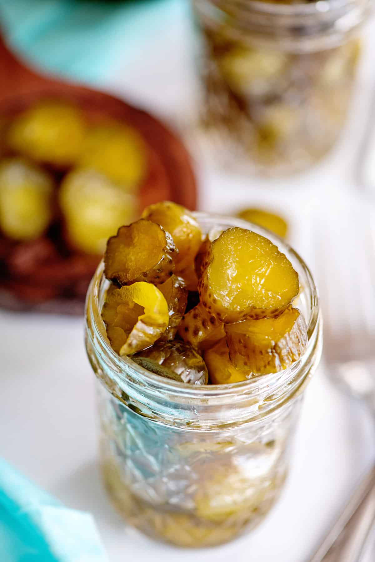 Jar of overflowing candied dill pickles.
