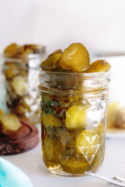 Jar of overflowing candied dill pickles.