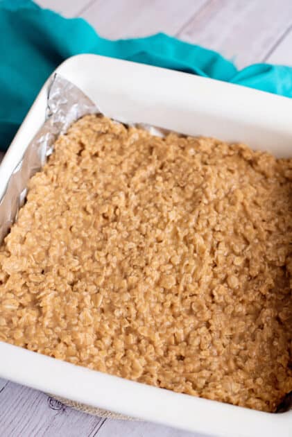 Peanut butter oatmeal cookie mixture pressed into baking dish.