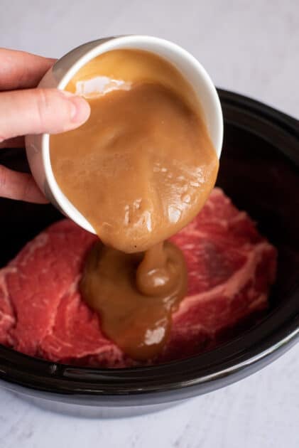 Pouring gravy over the raw roast