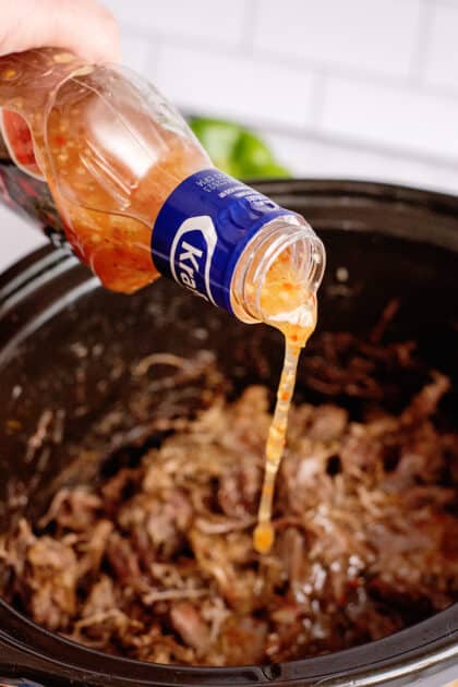 adding Italian dressing to the shredded beef