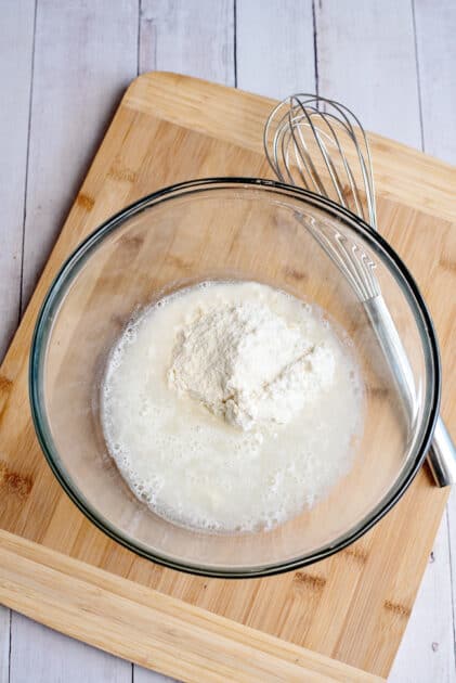Adding cornbread mix and water into a mixing bowl