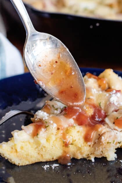 A slice of Monte Cristo Skillet on a plate with currant jelly being poured on top