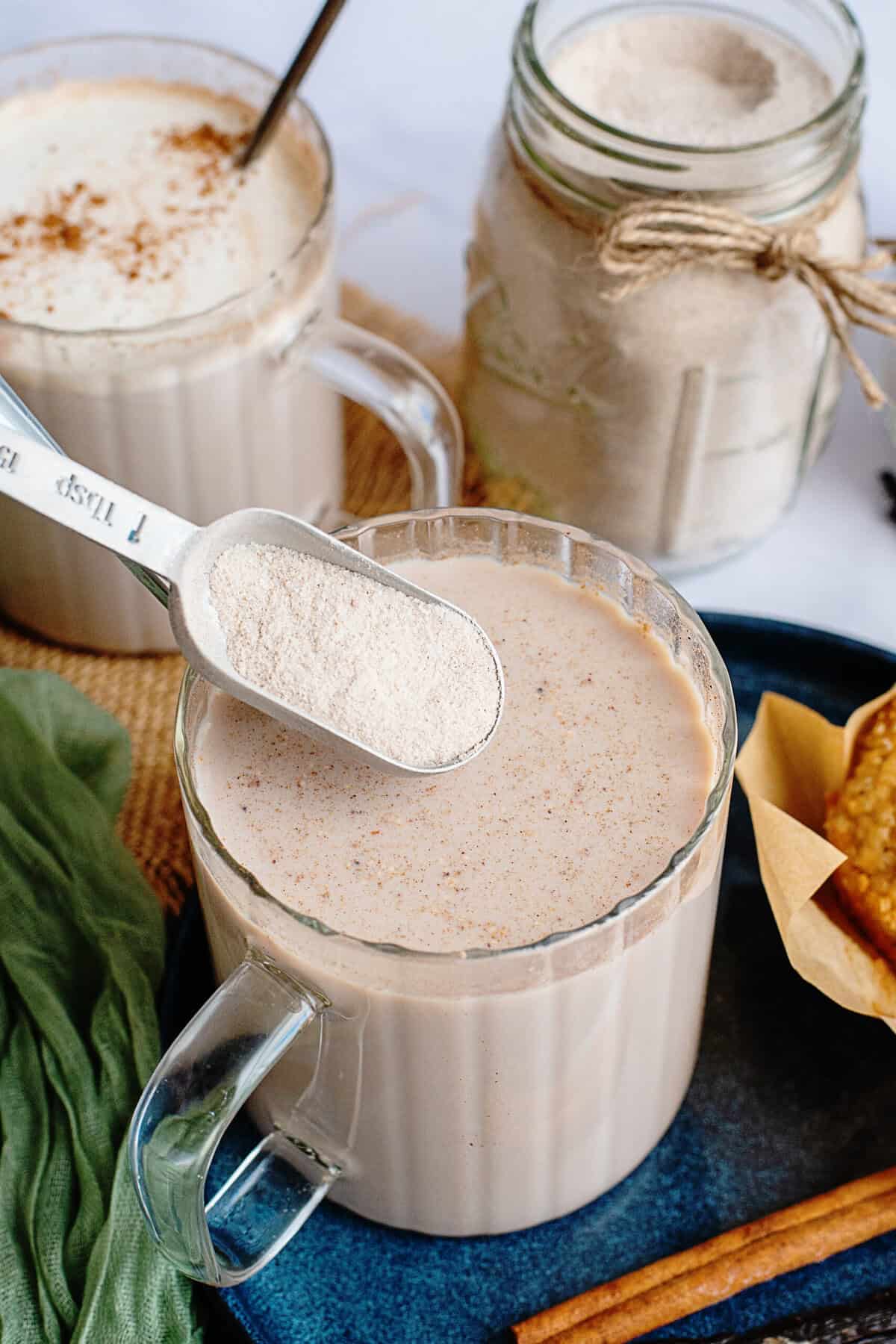 Adding vanilla chai powder mix to a glass of milk.