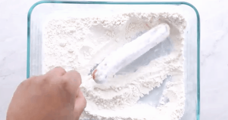 roll the hot dog in the flour until it is completed coated