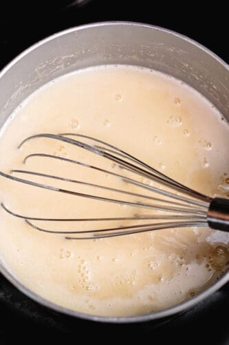 Whisking pudding mixture in saucepot.