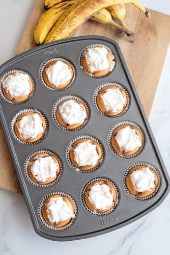Frozen banana pudding cups in muffin tin topped with Cool Whip.