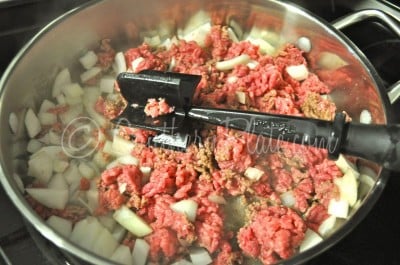 Cook onion and ground beef in skillet.