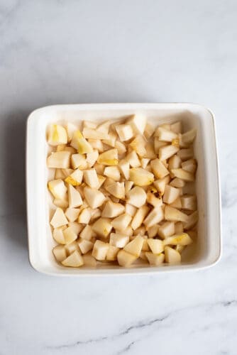 Peeled and diced pears in baking dish.