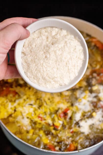 Adding potato flakes to a pot of country chowder.