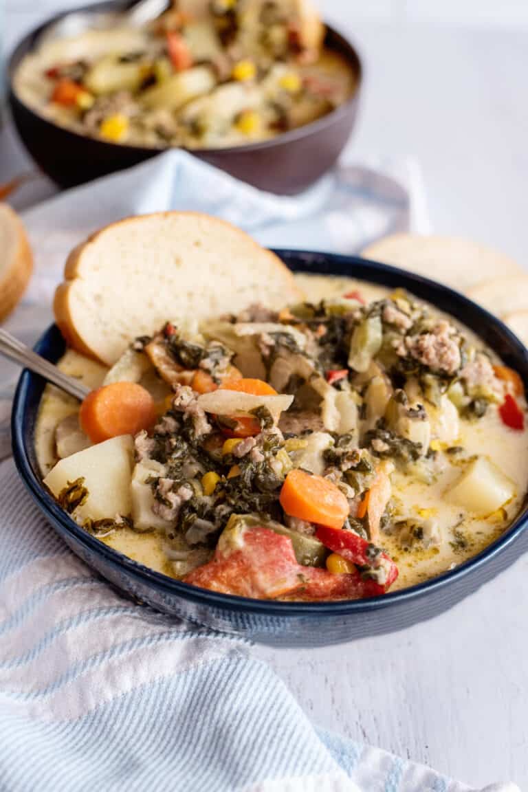 Country chowder in a wide bowl with a slice of bread.